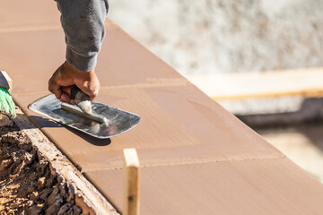 Wall Mural - Construction Worker Using Trowel On Wet Cement Forming Coping Around New Pool