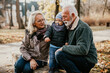 © hedgehog94 - Happy good looking senior couple husband and wife walking and playing with their adorable grandson in public city park