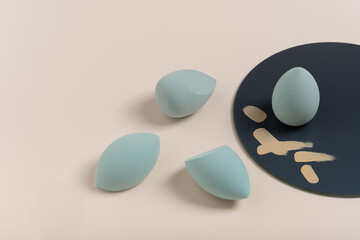 blue cosmetic makeup sponge on a beige nude background. A set of sponges of different shapes. Tool for applying foundation smears. Nobody. Beauty and fashion concept, make-up artist