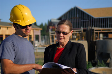 Contractor foreman discussing construction plans with the female architect