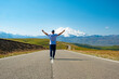 © margo1778 - A man walks along the highway against the backdrop of mountains. Freedom and travel concept. Elbrus, Caucasus.