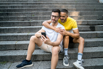 Wall Mural - Gay couple taking a selfie with mobile phone.