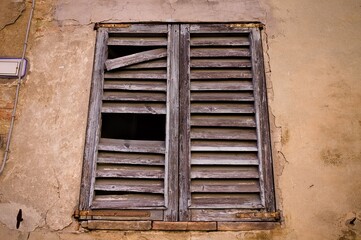 Wall Mural - A ruined window with a broken wooden shutter in a medieval italian village (Corinaldo, Marche, Italy, Europe)