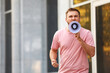 © New Africa - Emotional young man with megaphone outdoors. Protest leader