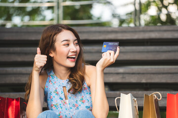 Wall Mural - Young asian shopaholic woman hold credit card for cashless