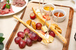 © Elena - cheese plate, slices of cheese, grapes, bread, honey on the Board on the table
