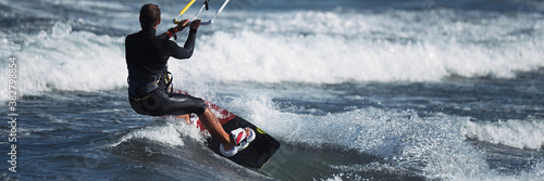 Plakaty Kitesurfing  wysportowany-mezczyzna-skacze-na-desce-surfingowej-latawiec-na-falach-morskich