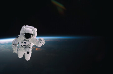 Wall Mural - astronaut walking in space with earth background. elements of this image furnished by nasa