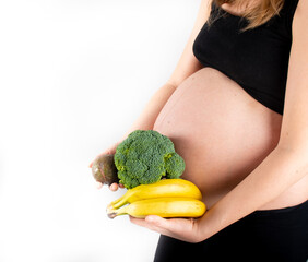 Wall Mural - Pregnant woman holding vegetables in hands. Healthy eating concept.