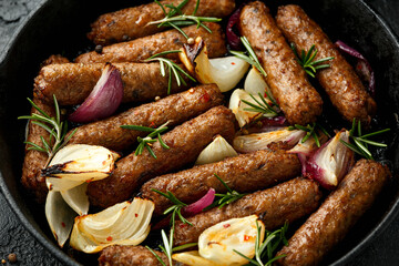 Wall Mural - Rosemary and onion vegetarian vegan sausages oven baked in cast iron skillet frying pan