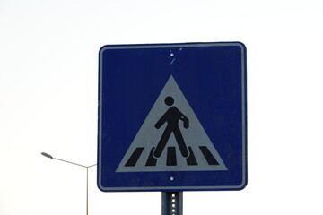 Pedestrian crossing sign black white on blue