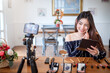 © amnaj - Young asian woman blogger recording video makeup cosmetic at home. Selling products online concept.