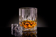 © Vladimir Sazonov - Crystal glass of whiskey with ice cubes on black background.