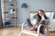 © BestForYou - Happy friendly woman in casual clothes in cozy chair at home.