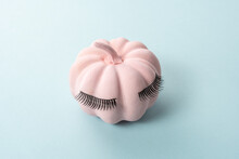 Pink Halloween Pumpkin With Lashes On Blue Background. Minimal Holiday Girl Concept.