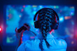 © Anton - Close-up view from back of gamer girl playing video game at home in front of big screen with joystick and headphone. Colorful neon led lights background. Streamer concept.