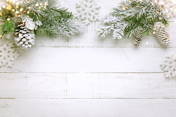 Wall Mural - Christmas tree branch with pine cone in snow and retro style clock on a white wooden background. Winter or Christmas festive concept. Flat lay, copy space.