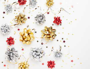 Christmas or New Year composition with colored sparkling ribbon decorations on white background. Flat lay, copy space