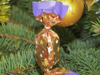 Wall Mural - Traditional original christmas fondant sweetness named szaloncukor in bright golden wrapping on the christmas tree in a family home in Budapest, Hungary