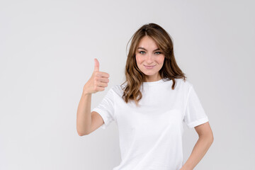 Wall Mural - Happy beautiful woman showing thumbs up symbol by one hand. Isolated on white background