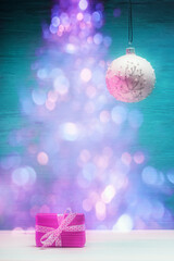 Wall Mural - Pink gift box and Christmas ball over holiday defocused lights. Xmas and New Year concept