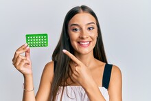 Young Hispanic Woman Holding Birth Control Pills Smiling Happy Pointing With Hand And Finger