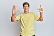 © Krakenimages.com - Handsome caucasian man wearing casual clothes showing and pointing up with fingers number seven while smiling confident and happy.