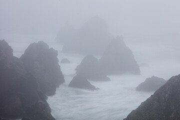 Wall Mural - The Pacific Ocean crashes against sea stacks along the foggy seashore of Northern California. This region, north of San Francisco, is known for its amazing coastal landscapes that extend to Oregon.