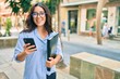 © Krakenimages.com - Young hispanic businesswoman smiling happy using smartphone at the city.