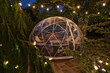 Individual tent igloo with vintage lighting overhead as a place to eat dinner