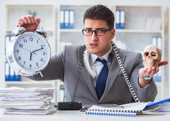 Sticker - Businessman smoking holding human skull and an alarm clock in th