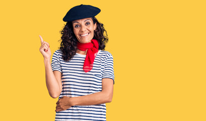 Wall Mural - Middle age beautiful woman wearing french beret and scarf smiling happy pointing with hand and finger to the side