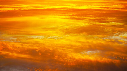 Wall Mural - Abstract orange red yellow background. Golden sunset over the clouds. Sky at sunset background. Cloudscape.
