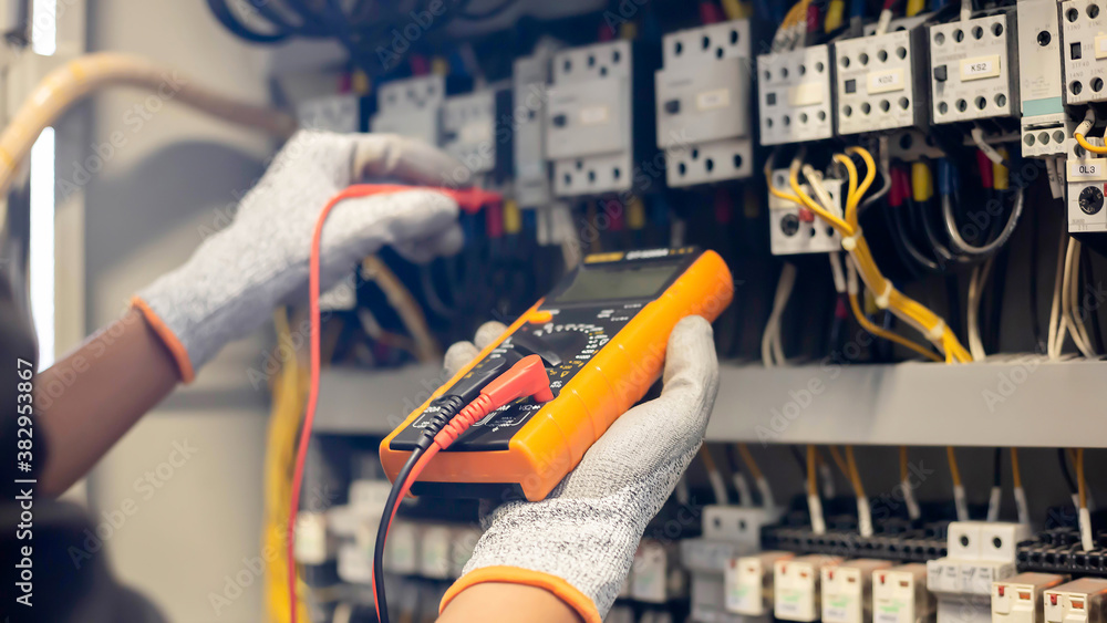 Electrician engineer uses a multimeter to test the electrical ...