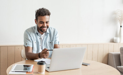 Young handsome man using laptop at home, Businessman or student working online on computer indoors, Freelance, online marketing, distance education, home work and technology concept