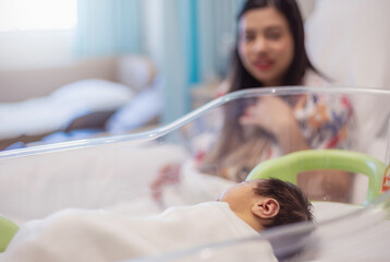 Indian mother with her newborn baby in hospital room. Mother with new born baby in post natal department. Motherhood health care concept