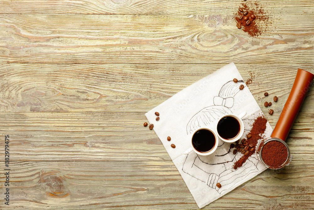 Creative composition with coffee powder and cups on wooden background