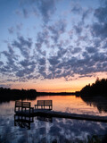 Fototapeta Pomosty - Sunset over a lake at the pier