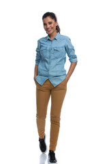 Wall Mural - cheerful smart casual woman smiling with both hands in pockets