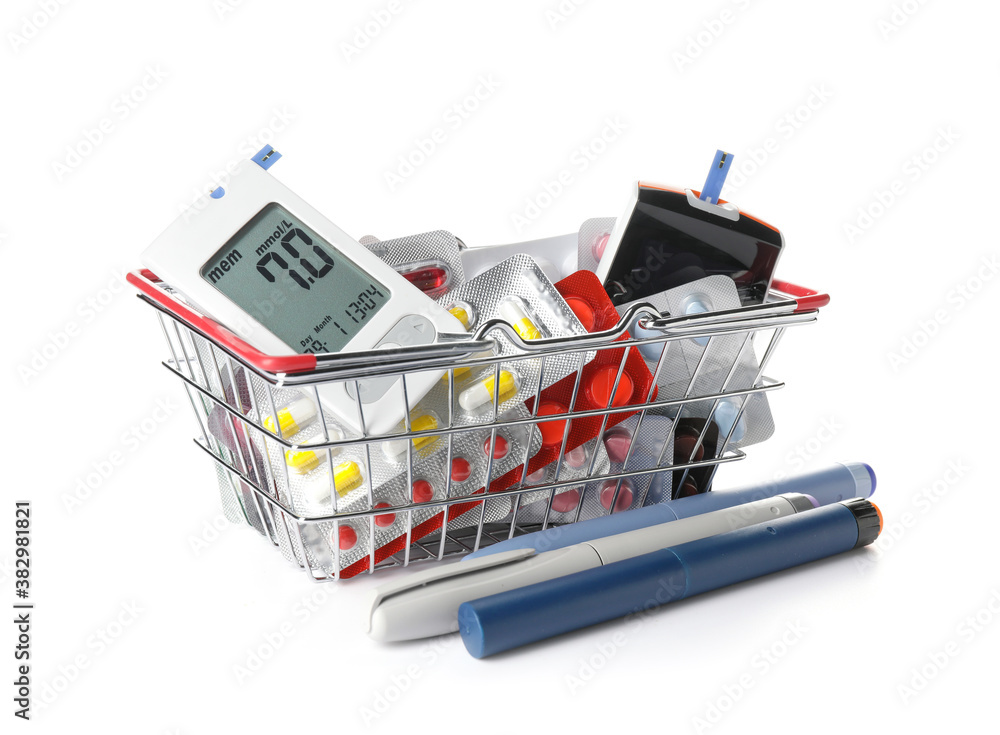 Shopping basket with glucometers, pills and lancet pens on white background. Diabetes concept