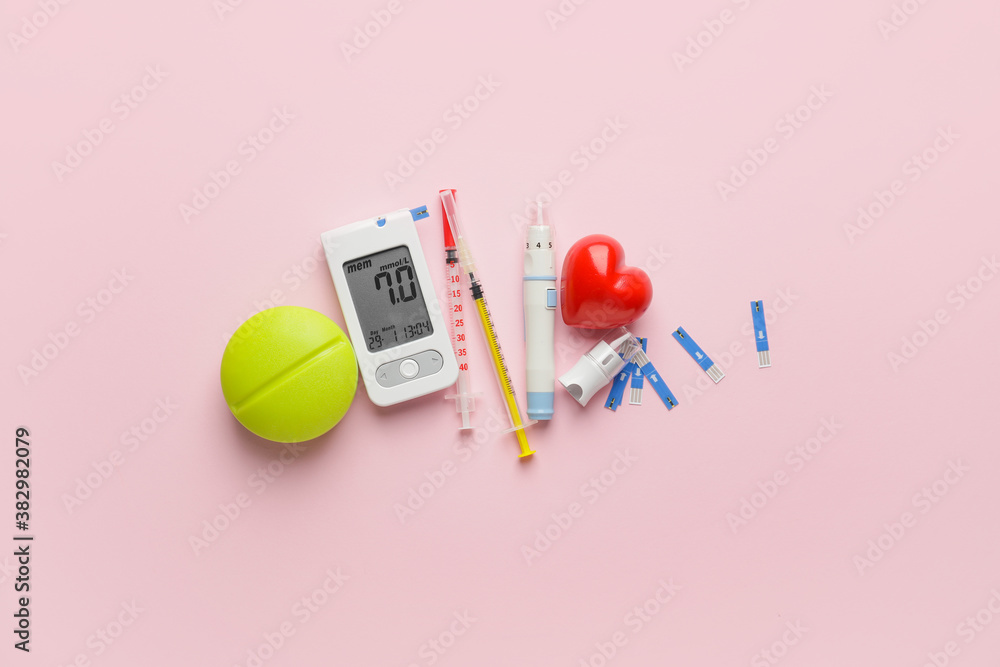 Glucometer with pills, syringes, strips and lancet pen on color background. Diabetes concept
