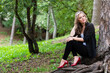 © ako-photography - young, beautiful girl sitting in the woods on the roots of a tree
