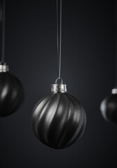 three twisted striped black christmas balls against dark gray background.