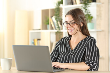 Wall Mural - Elegant woman wearing eyeglasses using laptop