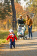 © Oleh - Happy kid walking in autumn park under the supervision of mom and grandmother