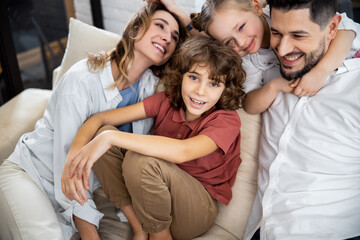 Wall Mural - Family with kids laughing while sitting on couch