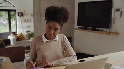 Poster - Zooming footage of an african american young woman working at her desk from home smiling and looking to camera