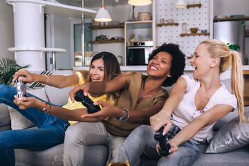 Portrait of happy women friends playing video games at home.