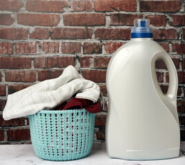 Wall Mural - plastic round laundry basket and gray bottle with liquid laundry powder