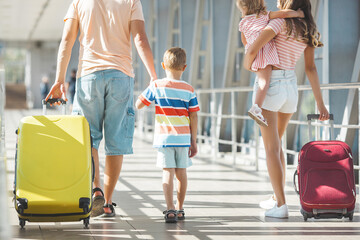 Wall Mural - Happy family at the airport with suitcases traveling